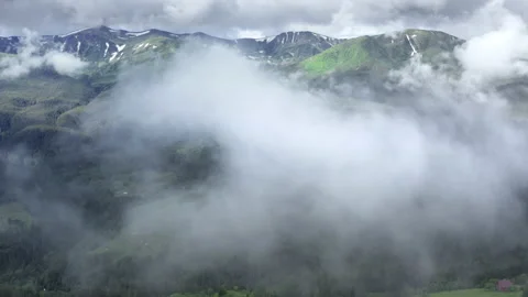 Aerial flight deep inside clouds high above mountain tops. High peaks covered by Stock Footage 135323297