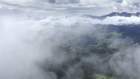 Aerial flight deep inside clouds high above mountain tops. High peaks covered by Stock Footage 135323894