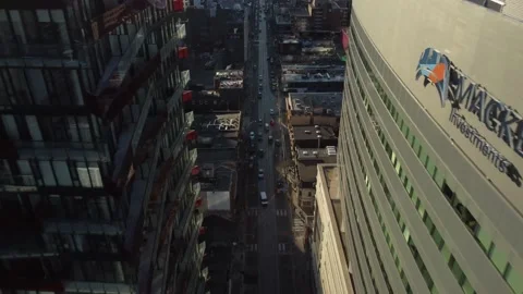 Aerial flight down and between two skyscraper that are separated by a road of tr Stock Footage 151921985