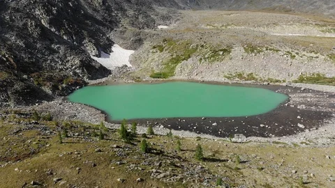 Aerial flight up to down under emerald mountain lake. Altai Video stock 103372244