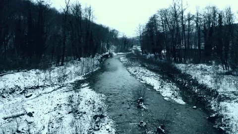 Aerial flight on drone above riverbed in mountain gorge. Winter river in snow Stock Footage 148508324