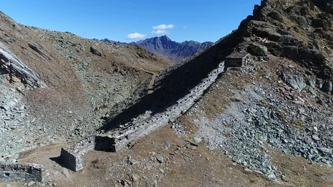Aerial flight with drone over First World War military walls in the Italian Alps Stock Footage 99728811