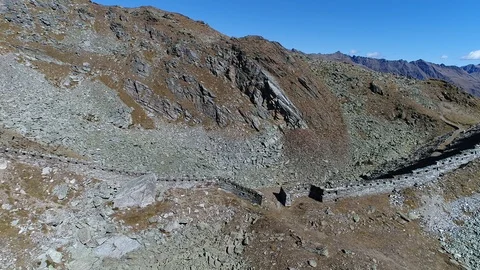 Aerial flight with drone over First World War military walls in the Italian Alps Stock Footage 99728935
