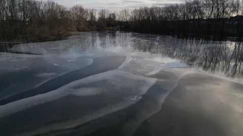 Aerial Flight (Fast) Over Ice Covered Area (Flooded Pond) during Winter in P Stock Footage 314202232