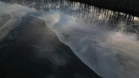 Aerial Flight Looking Down over Semi-Frozen Flooded Pond Area during Winter  Stock Footage 314202230