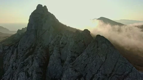 Aerial flight to meet the sunset through its rays in the mist which lies on the Stock-Footage 131086306
