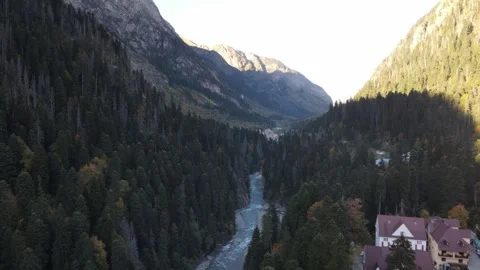 Aerial flight over alpine river valley and mountain settlement Stock Footage 337528836
