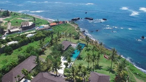 Aerial flight over beach resort and ocean Stock Footage 77556783