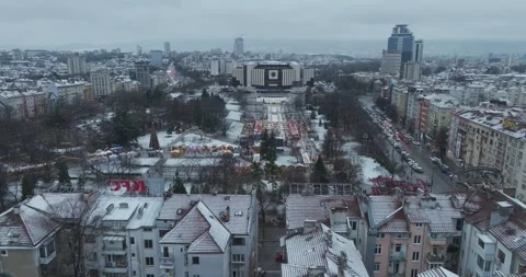 Aerial flight over the center of Sofia with a Christmas market and snow park Stock Footage 296228049