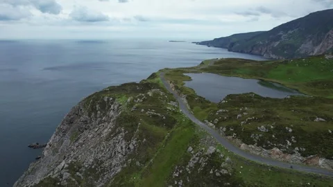 Aerial flight over cliff road and mountain lake at Slieve League, Ireland Stock Footage 346746281