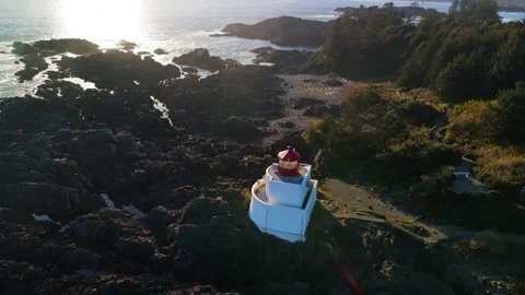Aerial flight over dense forest and rocky coast near the ocean and lighthouse Stock Footage 162064035