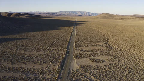 An aerial flight over an empty desert road. Video stock 155153670