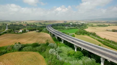 Aerial flight over the fields and next the highway. Aerial view in Tuscany Stock Footage 87093722