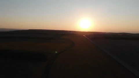 Aerial flight over fields of blooming sunflowers at sunset along road Video stock 142291526