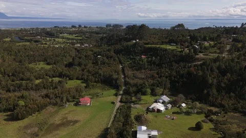 Aerial Flight Over Forest Hamlet with Bay in Background in Lenca Chile Video stock 325327828