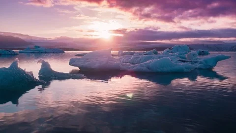 Aerial Flight Over Glaciers Particles Floating In Glacial Lake Purple Sunset Stock Footage