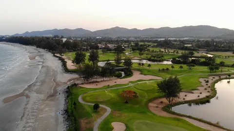 Aerial flight over golf course by the beach Stock Footage 107608697