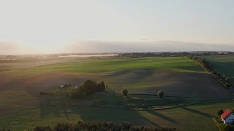 Aerial flight over green fields and sunset in Germany Stock Footage 116630380