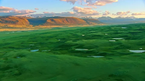Aerial flight over a green mountain valley with lakes at sunset Stock Footage 337023490
