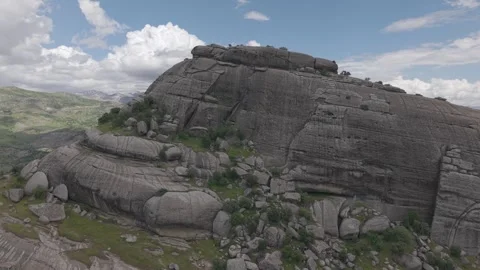 Aerial Flight Over Massive Rock Formation and Green Valley Stock Footage 344688076