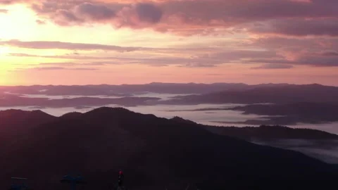 Aerial flight over mist during sunrise in mountains. Snowy Mountain Range Sil Stock Footage 164722987