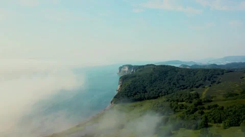 Aerial Flight Over Open Green Hill with Clear Sky and Horizon Stock Footage 335814722