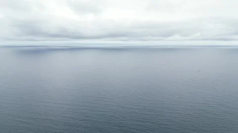 Aerial Flight over the Pacific Ocean with Clouds in the Distance Ahead Stock Footage 246409790