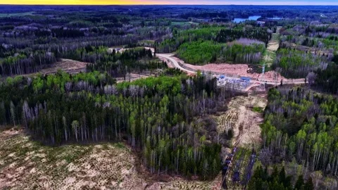 Aerial flight over a power line and substation construction site in a forest Vídeo Stock 337792052