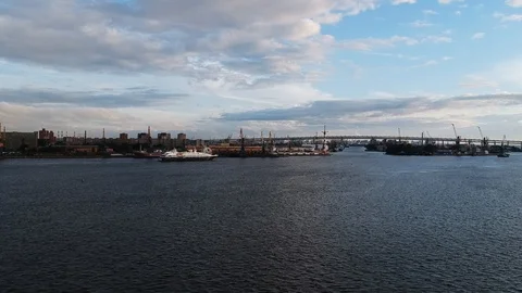 Aerial flight over river on which floating yacht and construction dock crane Stock Footage 96118726