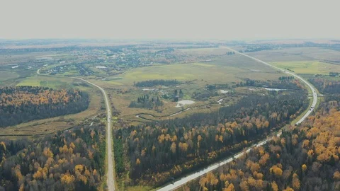 Aerial Flight over the road between fields and autumn trees in yellow, orange Stock-Footage 118071310