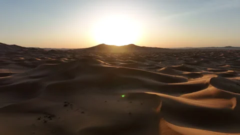 Aerial flight over rolling sand dunes in warm low sunlight Video stock 347843496