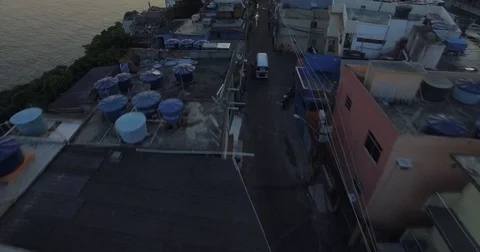 Aerial flight over the rooftops tilting upto a Favela. Rio De Janeiro, Brazil. Stock Footage 77749089