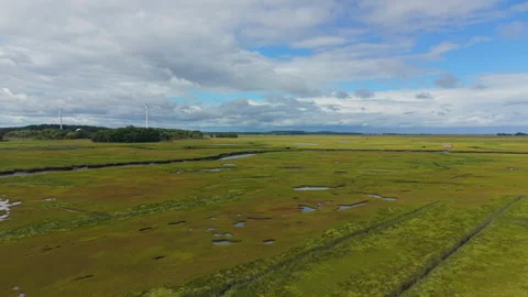 Aerial Flight Over Salt Marsh Toward Wind Turbines in Ipswich, Massachusetts Stock Footage 345699911