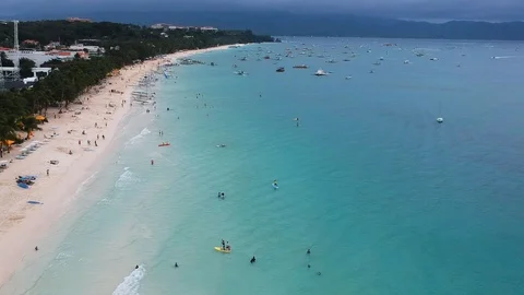 Aerial flight over sandy beach, waves and tourists on Cloudy Day Video stock 92876406