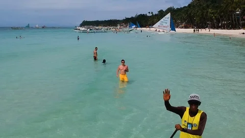 Aerial flight over sandy beach waves and tourists with Surfer Video stock 92929476