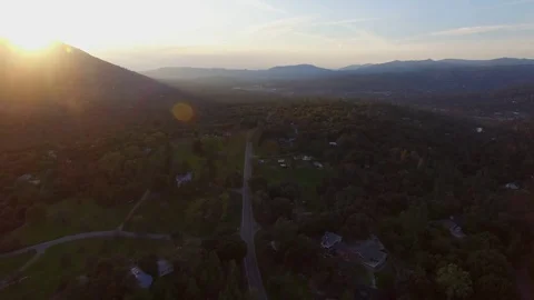 Aerial Flight Over Small Mountain Town and Road at Sunset Vídeos de archivo 77703988