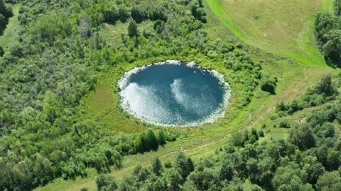 Aerial flight over small round lake. Ripple on water surface, windy summer day Stock Footage 136627192