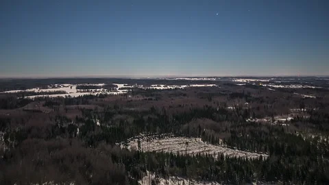 Aerial flight over a snowy forest landscape at night under a clear starry sky Stock Footage 344430531