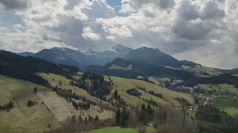 Aerial flight over spring landscape with clouds moving over mountains time lapse Stock Footage 74671121