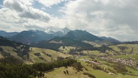 Aerial flight over spring landscape with clouds moving over mountains time lapse Stock Footage 82564750