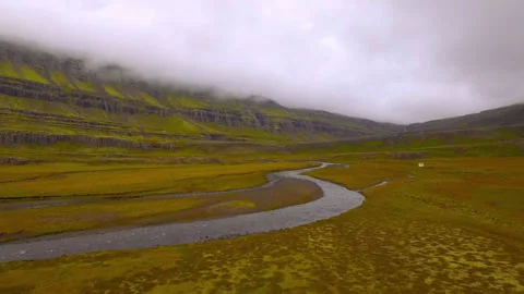 Aerial flight over a winding river in Iceland's green valley Vídeos de archivo 330282695