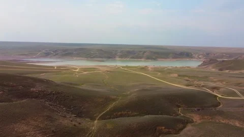 Aerial Flight Over Winding Road and Green Hills by Reservoir, Kazakhstan Stock Footage 332985104