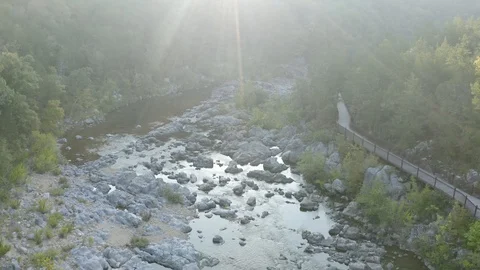 Aerial flight on a river with the sun's rays showing through a light fog 스톡 동영상 111581953