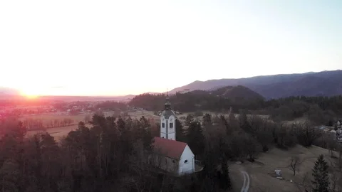 Aerial flight at the same height of the trees that surround the church. Stockbeeldmateriaal 125394247