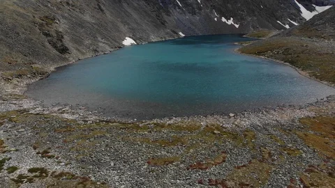 Aerial flight soaring under emerald mountain lake. Altai. Video stock 103372190