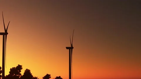 Aerial flight at sunset over renewable energy wind farm wind turbines Video stock 204840591