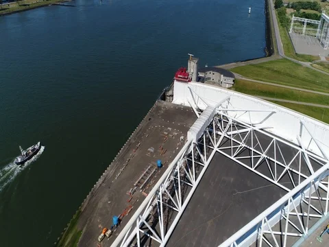 Aerial flight through storm surge barrier following ship moving through gates 4k Stock Footage 80531099
