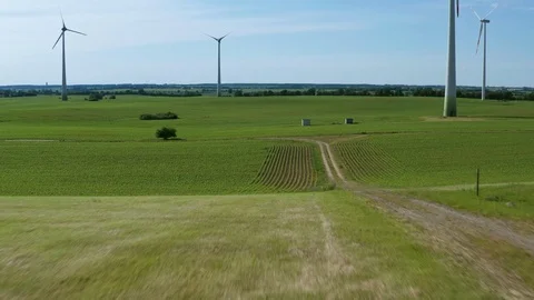 Aerial flight through windmills over green fields in Germany Stock Footage 116629122
