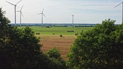 Aerial flight through windmills over green fields in Germany Stock Footage 116629702
