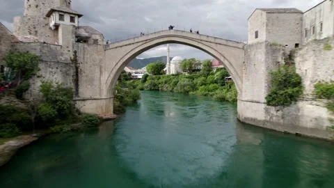 Aerial flight under famous old bridge in Mostar, popular touristtic destinati Stock Footage 237651693